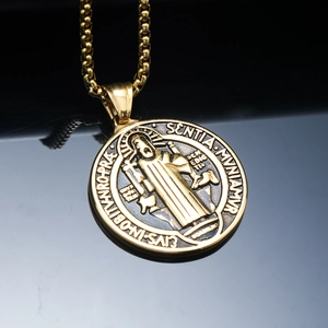 Macro detail of gold Saint Benedict Medal pendant with intricate religious engraving