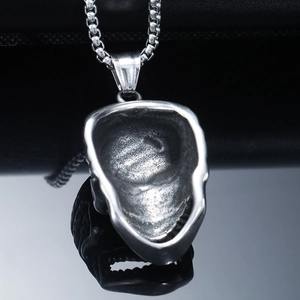 Makroansicht der hohlen Rückseite des Vintage-Silber-Totenkopfanhängers an der Kette
