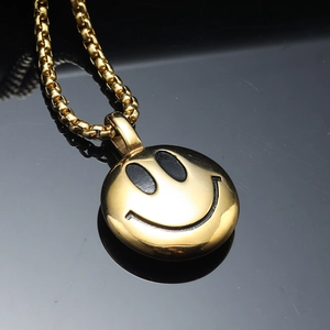 Polished gold round smiley face pendant necklace with chunky link chain on black background