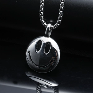 Macro shot of silver smiley face pendant on a stainless steel square pearl chain necklace