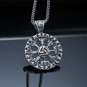 Macro shot of Viking Valknut pendant with golden runes on a polished steel disc