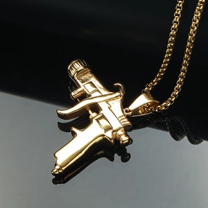 Collar con colgante de pistola punk gótica en acero inoxidable dorado sobre fondo negro