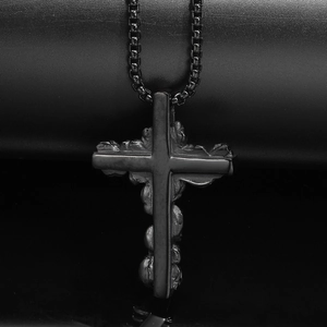 Close-up of black punk cross pendant with gothic skull texture and beaded chain necklace
