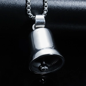 Macro detail of high-polished stainless steel bell pendant with box chain on black backdrop