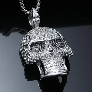 Macro shot of silver hip-hop skull pendant with white rhinestones and square link chain
