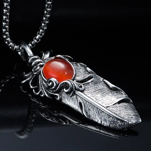 Pendentif plume en acier inoxydable vintage avec pierre rouge sur fond noir