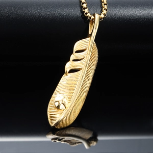 Minimalistischer goldener Federanhänger mit feiner Textur auf schwarzem reflektierendem Grund