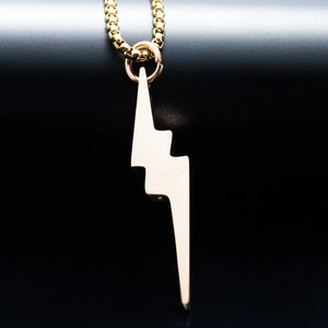 Vue macro du pendentif éclair doré minimaliste sur une chaîne à mailles carrées