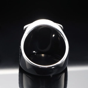 Punk eagle head signet ring in silver stainless steel on a reflective black background