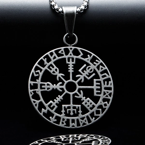Macro shot of silver vintage Viking compass pendant with Rune circle on black reflection