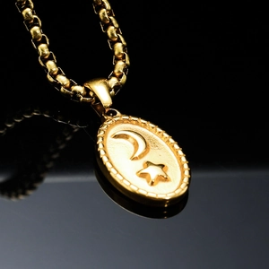 Polished gold stainless steel moon and star oval pendant necklace on black background