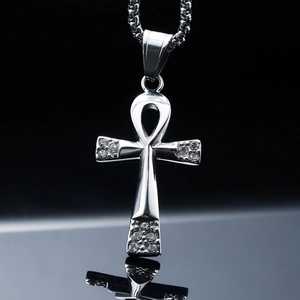 Detailed close-up of a silver polished Ankh cross pendant with sparkling rhinestones
