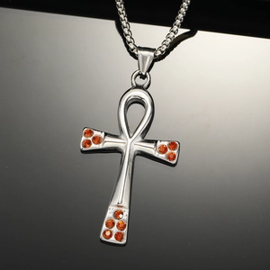 Detail of silver Ankh cross pendant with orange rhinestones and box chain necklace
