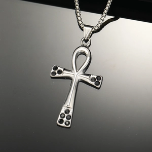 Detailed close-up of silver Ankh cross pendant with black crystals and box chain link