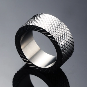 Polished silver stainless steel ring with diamond pattern engraving on gray background