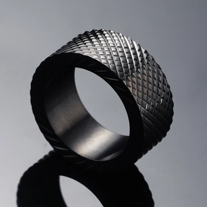 Macro shot of black stainless steel ring with fine diamond texture and spiral edge details
