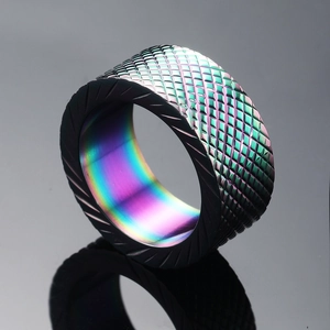 Industrial knurled stainless steel ring with rainbow interior in a reflective studio setting