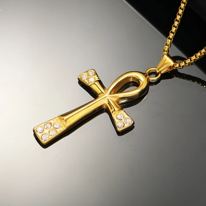 Detailed close-up of golden Ankh cross pendant with sparkling diamond accents on box chain
