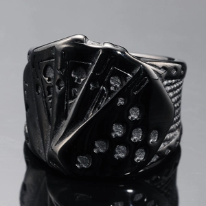 Macro shot of punk poker flush pattern on black stainless steel ring with reflections