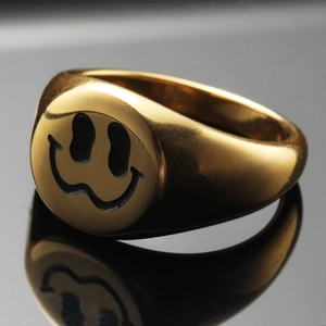 Minimalist golden stainless steel signet ring with a melting smiley face design