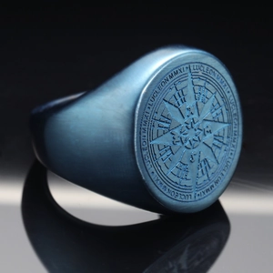Macro shot of matte blue stainless steel signet ring with compass engraving and LUCLEON logo