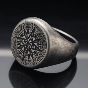 Macro detail of punk septagram compass ring with vintage silver finish and engraved letters