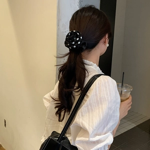 Elegant black polka dot rose scrunchie with silk texture for sophisticated hair styling