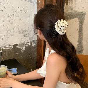 Close-up of elegant cream polka dot rose scrunchie worn in a soft low ponytail