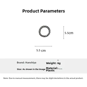 Close-up of a 5.5cm black polka dot spiral hair tie with product dimension specifications
