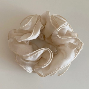 Dettaglio dell'elastico in rete bianco crema con texture setosa e bordi a onde morbide