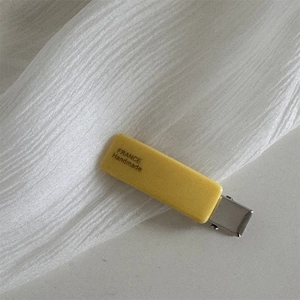 Detail view of handmade yellow rectangle matte hair clip with metal duckbill base