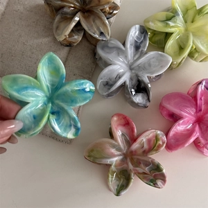 Detailaufnahme der bunten Blumen-Haarklammern in verschiedenen Acetat-Mustern