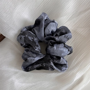 Macro shot of silk satin scrunchie with Chinese ink wash tie-dye and glossy texture