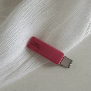 Detailed macro view of a pink acetate hair clip with silver clip and France Handmade text