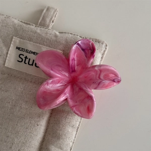 Nahaufnahme der Haarspange in Blumenform mit rosa Marmormuster auf einer Leinentasche