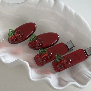 Detailed macro view of 4-piece cherry hair clips set on shell decorative tray