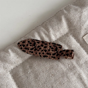 Detailed close-up of retro leopard print duckbill hair clip with a matte finish texture