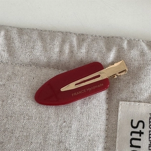 Close-up of red popsicle acetate hair clip with France Handmade gold engraving