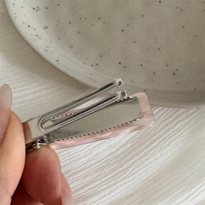 Detail view of pink marble acetate duckbill hair clip with anti-slip alloy base