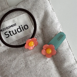 Detailaufnahme von Haarband und Haarspange mit rosa Blumen aus Acetat auf Leinwand