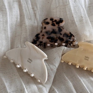 Detailed view of jelly-textured acetate hair claws in leopard, cream, and beige tones