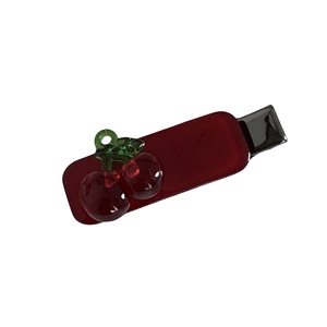 Translucent red cherry hair clip with green leaves in a minimalist duckbill design