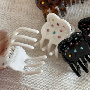 Detail of butterfly hair claw clip with colorful rhinestones and metal spring mechanism