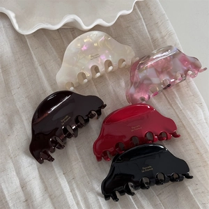 Detailed set of medium acetate hair claws in five colors with golden logo branding