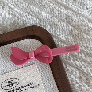 Detailansicht der rosa Acetat-Schleifen-Haarspange mit France Handmade Gravur auf der Seite