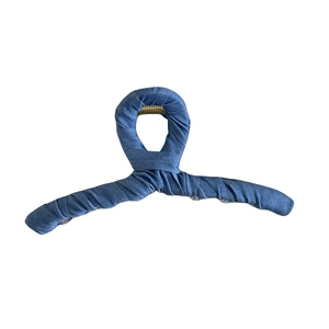 Detail of the blue denim fabric texture and golden spring on a large shark hair clip
