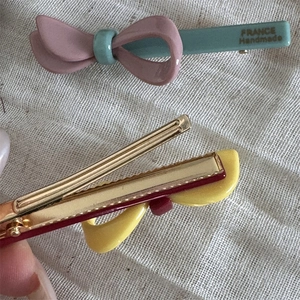 Detailansicht der bunten Schleifen-Haarklammer mit Gold-Metallclip und Harz-Oberfläche