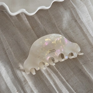 Close-up of pearl acetate hair claw with Barrette la France logo on light background
