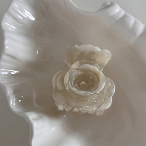 Detalle de pinza para el pelo rosa blanco crema con textura de mármol en bandeja