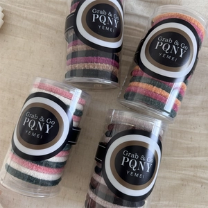 Close-up of four jars containing assorted colorful high-elasticity knitted velvet hair ties
